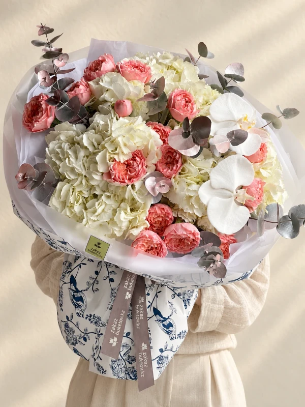 Букет "Нежная симфония" с гортензиями, пионовидными кустовыми розами и орхидеями — «Нежная симфония» — гармоничный букет из 5 гортензий, 5 роз, 2 орхидей и 2 ветвей эвкалипта.